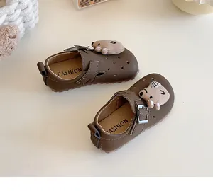Detailansicht der braunen Kinderslipper mit süßem Plüschbärenaufnäher und Schnalle.