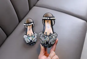 Detailed view of black girl's princess shoes featuring a luxury butterfly rhinestone ornament.