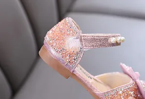 Close-up of pink glitter girl shoe with sparkling rhinestones and pearls