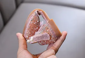 Detailed view showing the flexibility of pink glitter princess flats for little girls