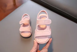 Nahaufnahme von rosafarbenen Kleinkindsandalen mit weicher Sohle und Klettverschluss