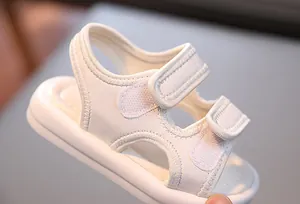 Nahaufnahme von weißen, atmungsaktiven Kleinkindersandalen mit praktischem Klettverschluss