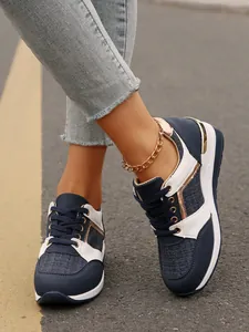 Λεπτομερής άποψη γυναικείων sneakers με πλατφόρμα σε μπλε σκούρο και χρυσές πινελιές
