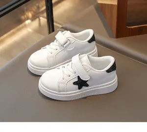 Gedetailleerd zijaanzicht van witte leren kindersneakers met een zwarte glitterster