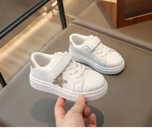 Detailopname van witte lederen kindersneakers met een gouden glitterende sterren