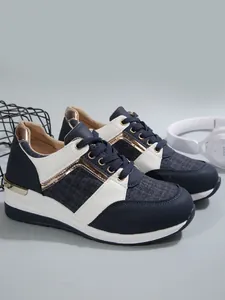 Λεπτομερής όψη των sneakers σε ναυτικό μπλε και λευκό με κομψές μεταλλικές πινελιές ροζ χρυσού.
