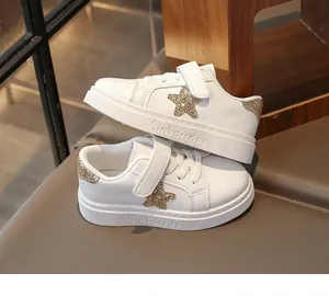 Macro-detail van witte kindersneakers met een stijlvolle glanzende gouden ster.