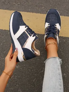 Λεπτομέρεια από μπλε και λευκά patchwork sneakers με χοντρή σόλα και χρυσές πινελιές