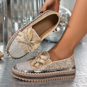 Primer plano de mocasines con plataforma de purpurina y lazo de strass.