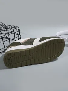Κοντινό πλάνο της πράσινης σόλας από καουτσούκ σε γυναικείο αθλητικό παπούτσι.