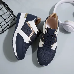 Λεπτομέρεια γυναικείων sneakers με πλατφόρμα σε μπλε και χρυσό μοντέρνο σχέδιο.