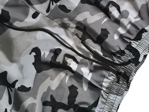 Primer plano de pantalones cargo de camuflaje gris con cordón y cintura elástica.