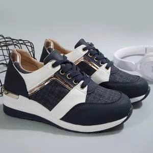 Λεπτομέρεια από μπλε και λευκά sneakers με μεταλλικές λεπτομέρειες σε ροζ χρυσό και πλέγμα.