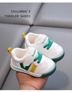 Close-up of white toddler walking shoes with green accents and easy velcro straps