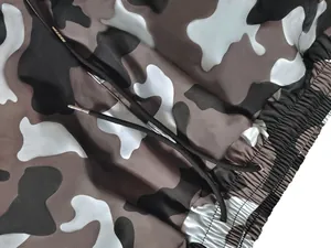 Detalle de pantalones cargo de camuflaje con cintura elástica y cordón con puntas de metal