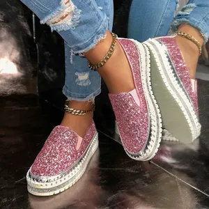 Close-up of pink glitter platform loafers with rhinestone detailing and gold anklets