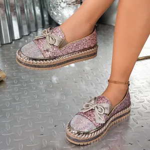 Vista detallada de mocasines de purpurina rosa con punta de strass y lazo elegante