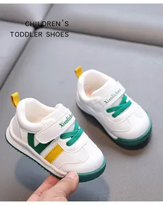 Detailed view of white toddler sneakers with green and yellow accents and soft sole