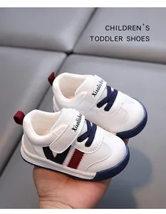 Close-up of white toddler walking shoes with soft non-slip soles and blue laces