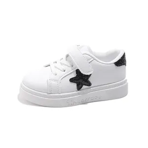 Stijlvolle witte leren kindersneakers met zwarte glitterster en klittenbandsluiting