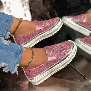 Detailed macro shot of pink glitter slip-on loafers featuring thick white platform soles