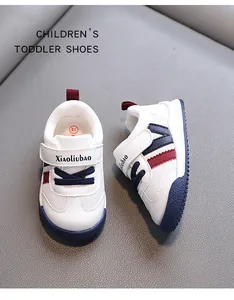 Close-up of white toddler sneakers with red and blue accents and non-slip sole