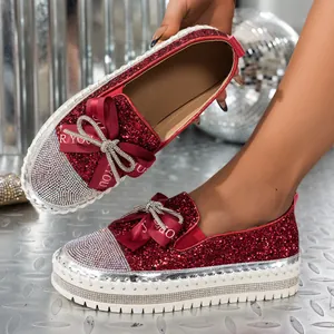 Detalle de los mocasines de plataforma con purpurina roja y lazo de diamantes