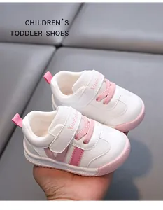 Detail of white toddler walking shoes with pink accents and soft non-slip sole.