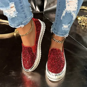 Close-up of red glitter slip-on platform shoes with rhinestone detailing
