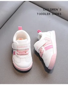 Macro top-down view of white and pink baby toddler shoes with mesh panels and Velcro straps