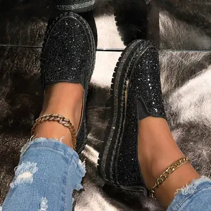 Detail of black glitter platform loafers with sparkling rhinestone trim and slip-on design