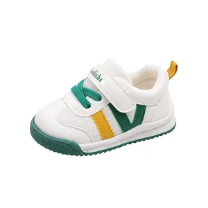 Toddler white leather walking shoe with green and yellow accents and adjustable velcro strap
