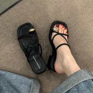Detailansicht schwarzer Plateausandalen mit Zehenring aus Metall und Kreuzriemendesign