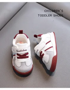 Detail view of toddlers white walking shoes with burgundy accents and soft anti-slip soles