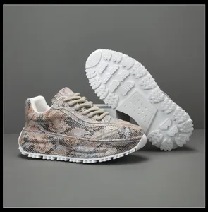 Détail du motif en peau de serpent et de la semelle en caoutchouc blanc des baskets