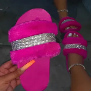 Detailed close-up of vibrant pink fuzzy slippers featuring a luxury sparkling rhinestone band