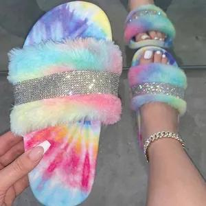 Close-up detail of colorful tie-dye faux fur slippers featuring a sparkling rhinestone strap