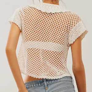Detalle de cárdigan de ganchillo blanco de manga corta con cuello y calado para vacaciones de verano.