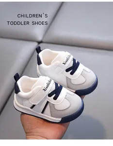 Detail view of white and blue soft-sole toddler shoes with adjustable velcro straps