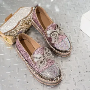 Detalle de mocasines rosa con purpurina, lazo de pedrería y suela de plataforma gruesa