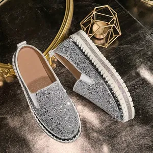 Detailed close-up of silver glitter slip-on loafers featuring rhinestone platform soles