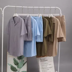 Ensembles d'intérieur pour hommes en coton et lin présentés sur un portant blanc moderne.