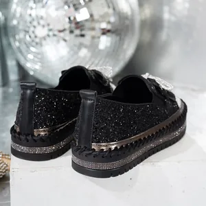 Vista detallada de mocasines negros con purpurina y plataforma con brillantes detalles de strass