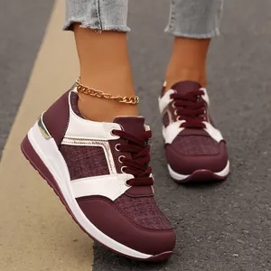 Κοντινό πλάνο γυναικείων sneakers με πλατφόρμα σε μπορντό και λευκό χρώμα στο δρόμο