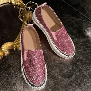 Detail view showing pink glitter texture and rhinestone accents on platform loafers.