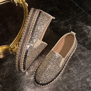 Close-up detail of sparkling champagne glitter platform loafers with rhinestone side accents.