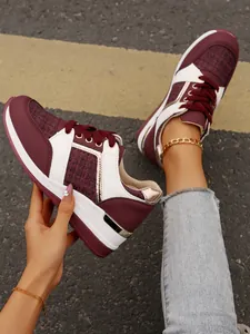 Λεπτομερής προβολή γυναικείων sneakers με πλατφόρμα σε μπορντό και λευκό με χρυσές λεπτομέρειες