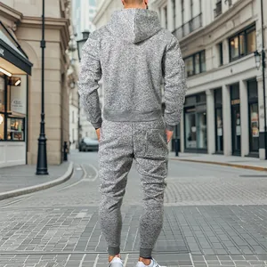 Vista trasera de un chándal de forro polar gris con capucha y joggers en una escena urbana.