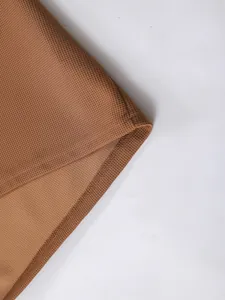 Nahaufnahme von braunem Waffelstrickstoff mit hochwertiger Overlock-Naht am Herrenoberteil