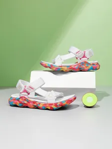 Vue détaillée de sandales colorées pour filles avec brides blanches et semelles camo.